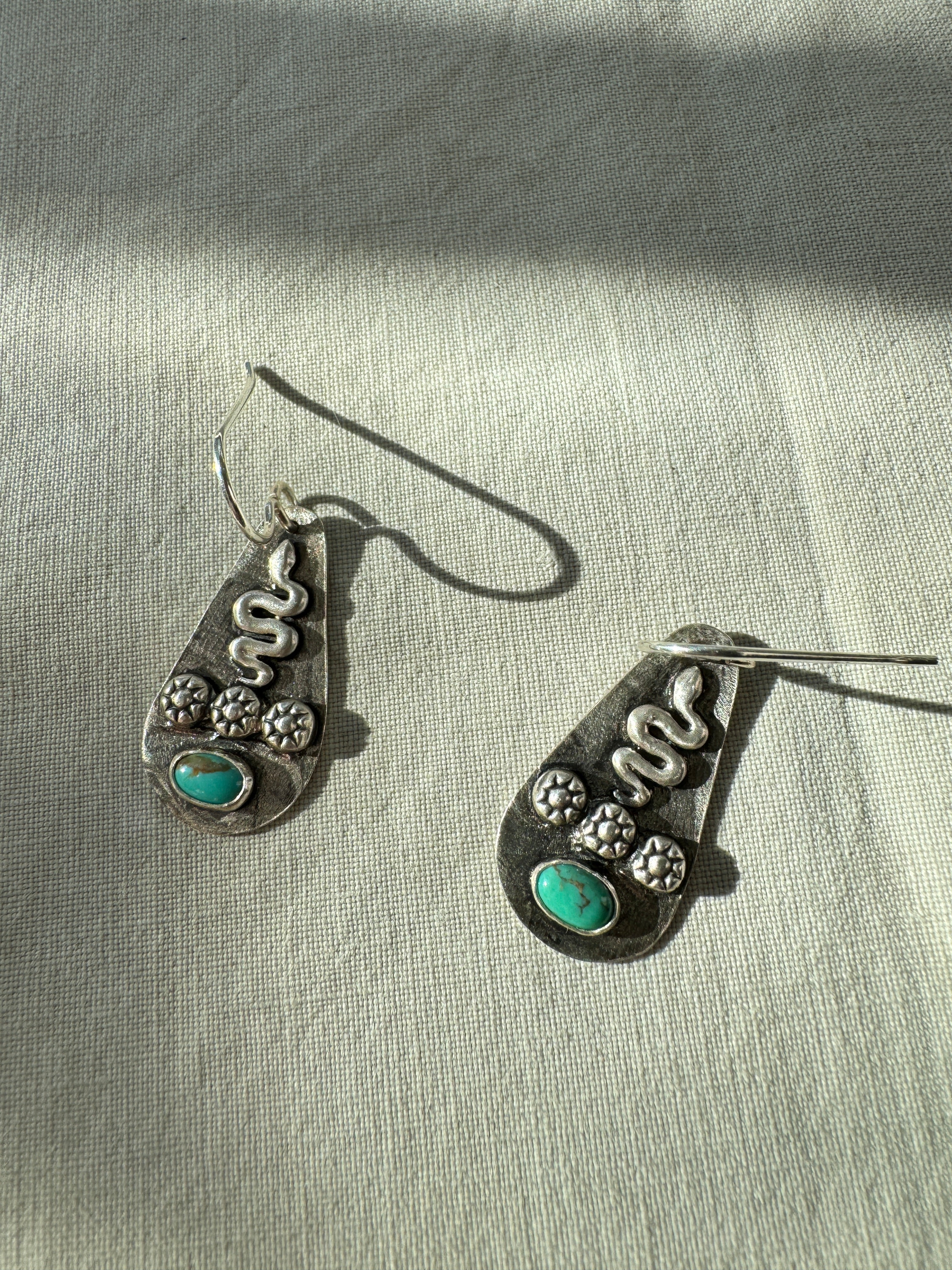 Sterling silver earrings with sterling silver snakes and carico lake turquoise. The ear wire is sterling silver. This is a one of a kind pair.