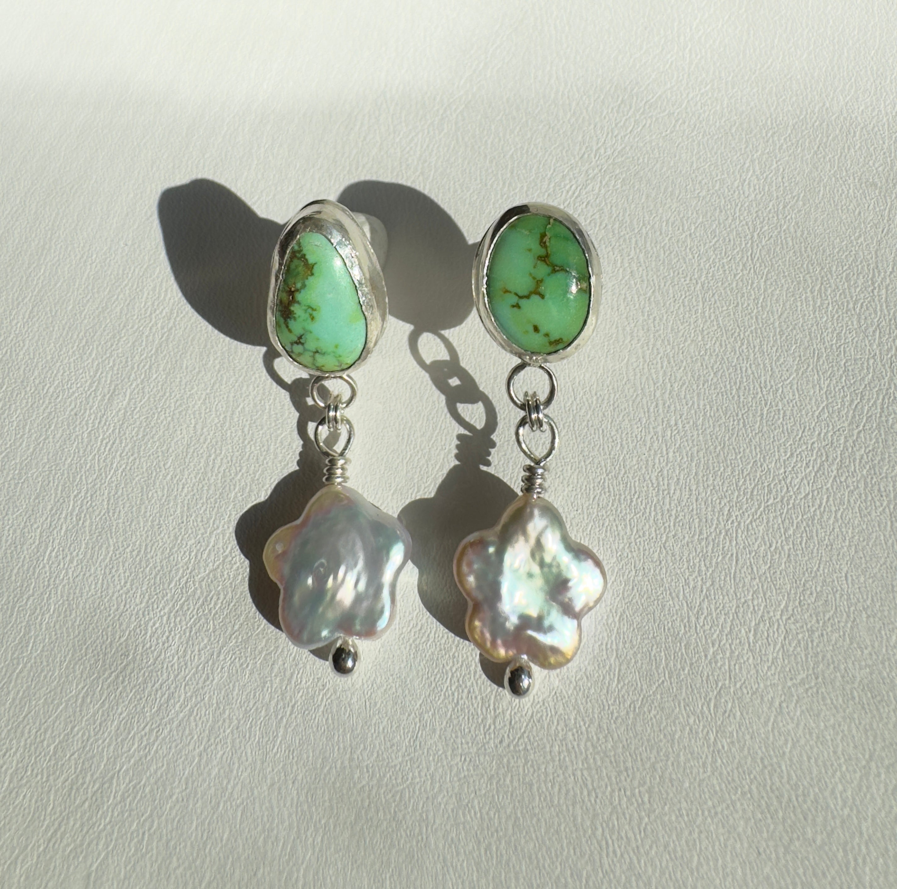 Verde Valley Turquoise set in a fine silver bezel with flower shaped pearls dangling below. The posts and ear backs are sterling silver.