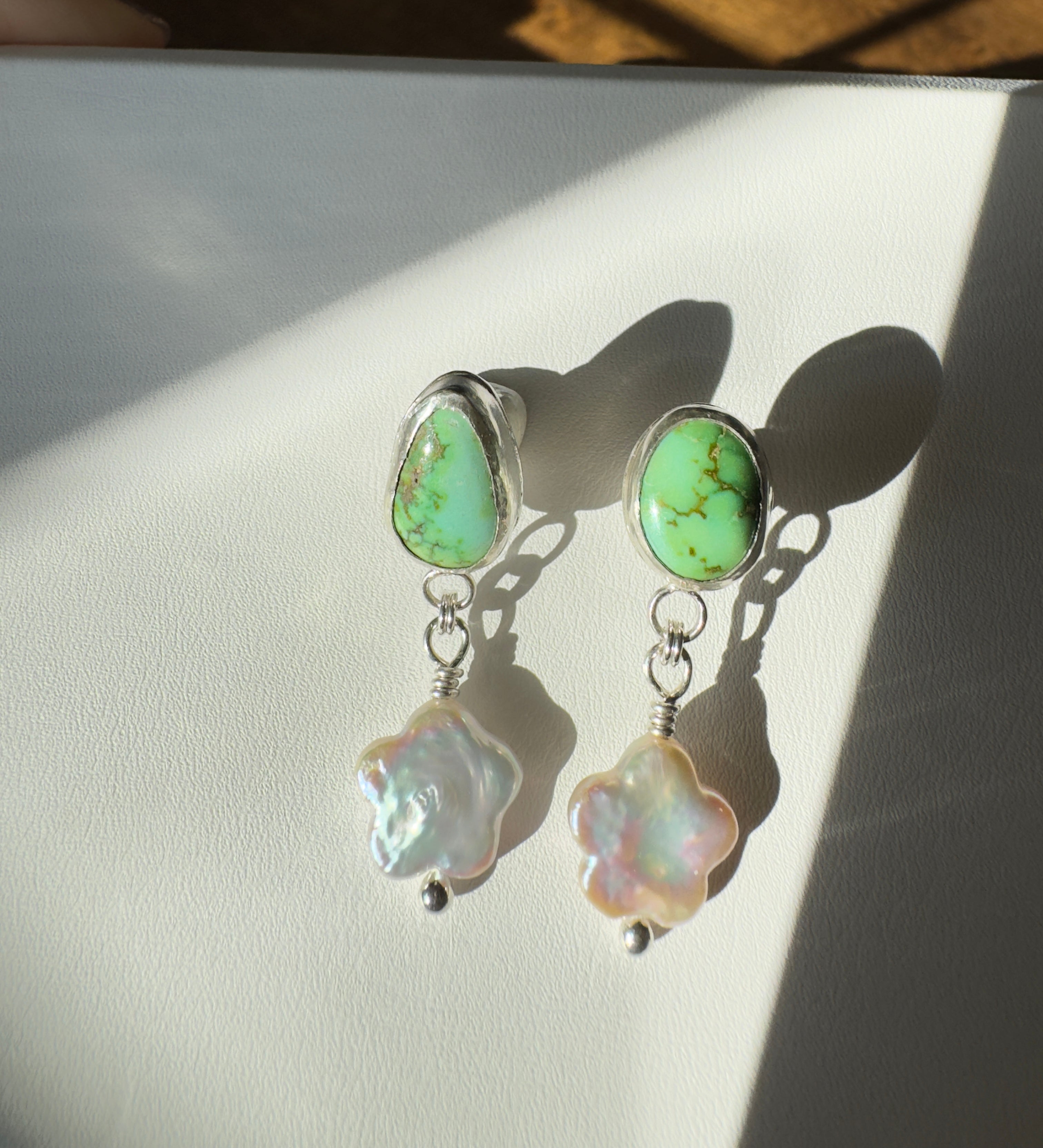 Verde Valley Turquoise set in a fine silver bezel with flower shaped pearls dangling below. The posts and ear backs are sterling silver.