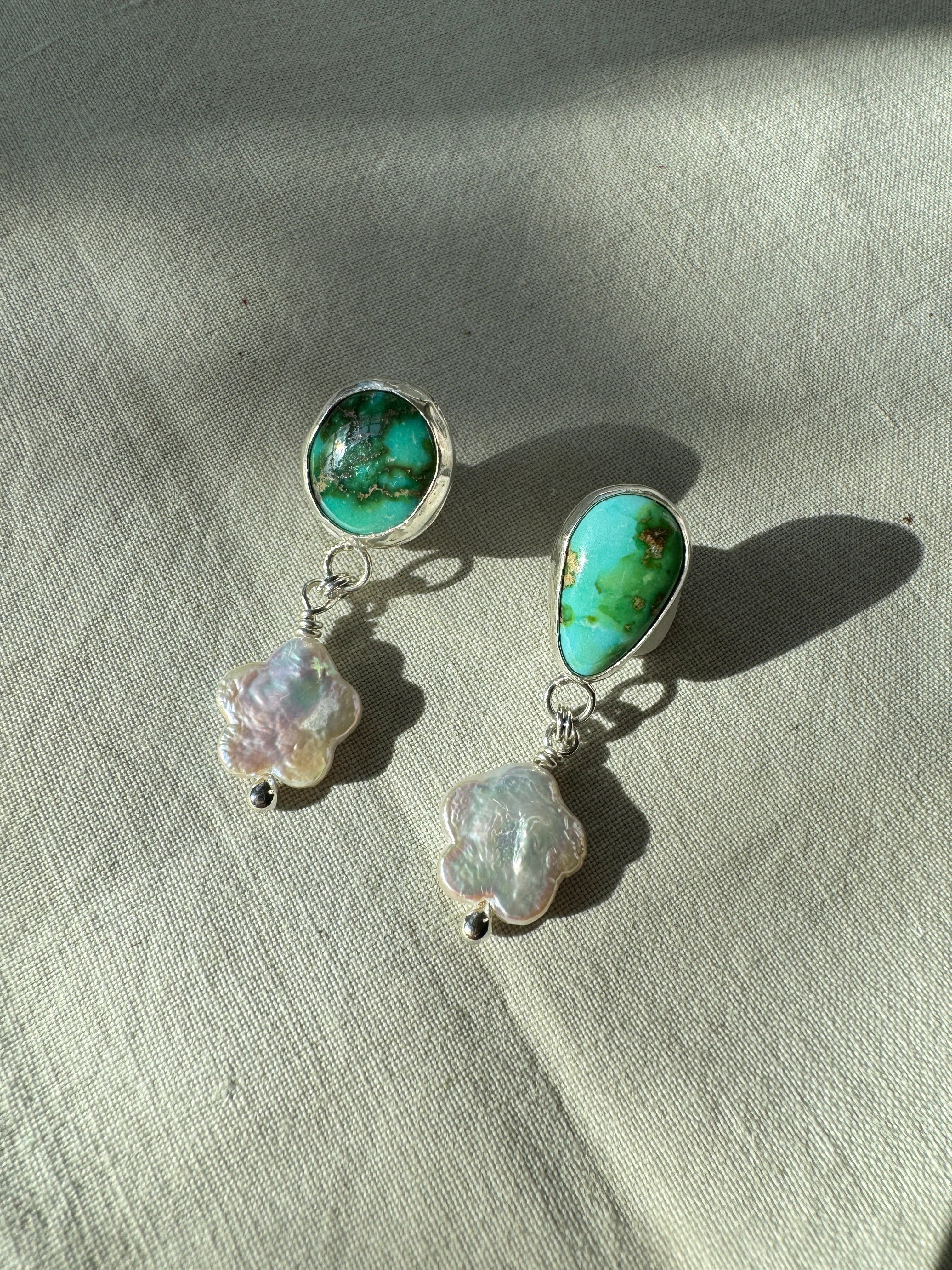 Verde Valley Turquoise set in a fine silver bezel with flower shaped pearls dangling below. The posts and ear backs are sterling silver.