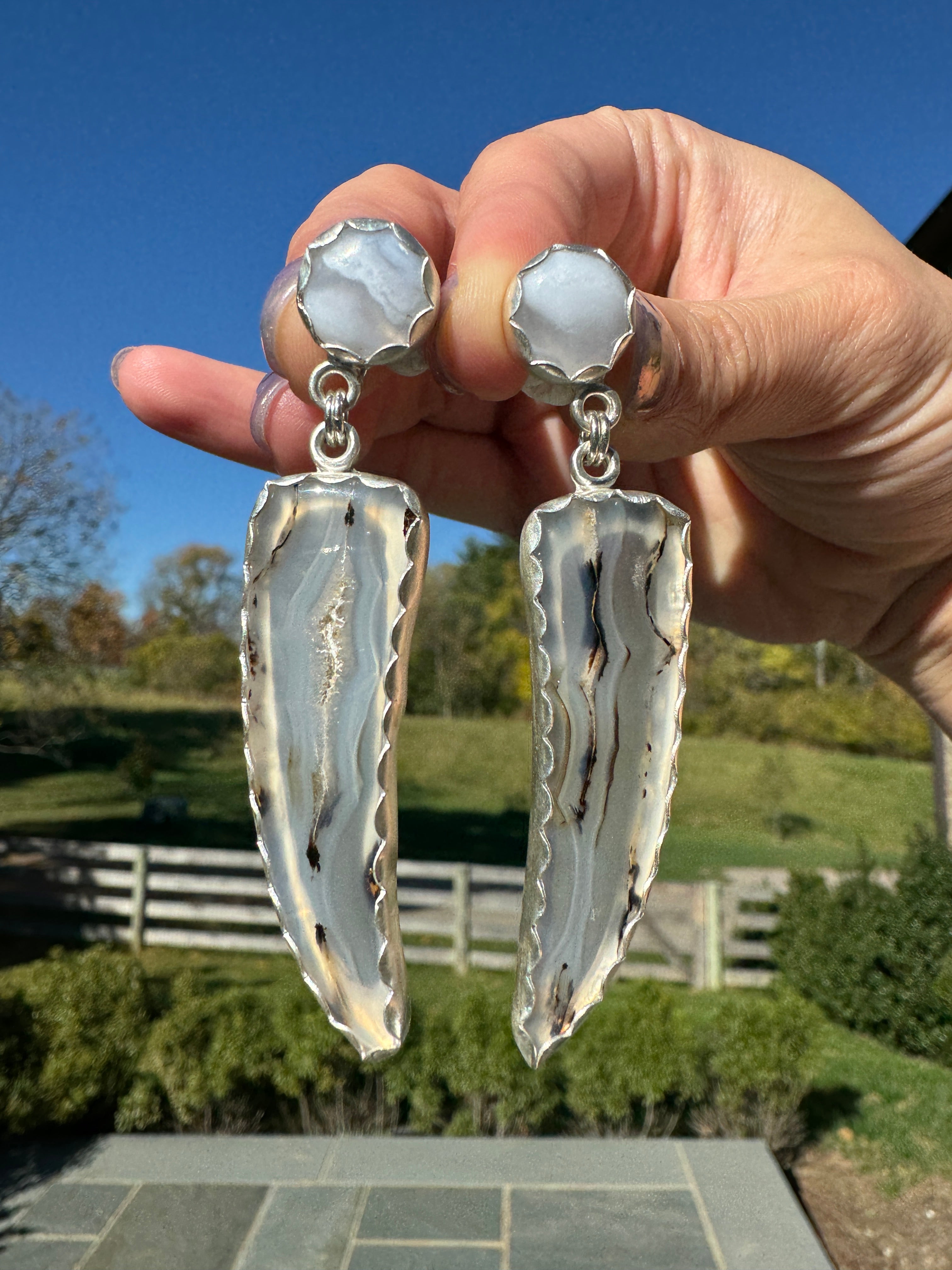 Gorgeous Montana Yellowstone Agate wrapped in fine silver and dangling from periwinkle chalcedony studs. This Montana agate was dug and cut by a Montana born female miner, making this pair extra special. These look stunning on, especially when the light hits the agate because I cut out most of the silver in the back to allow light to shine through and also keep these very lightweight and easy to wear. One of a kind pair.