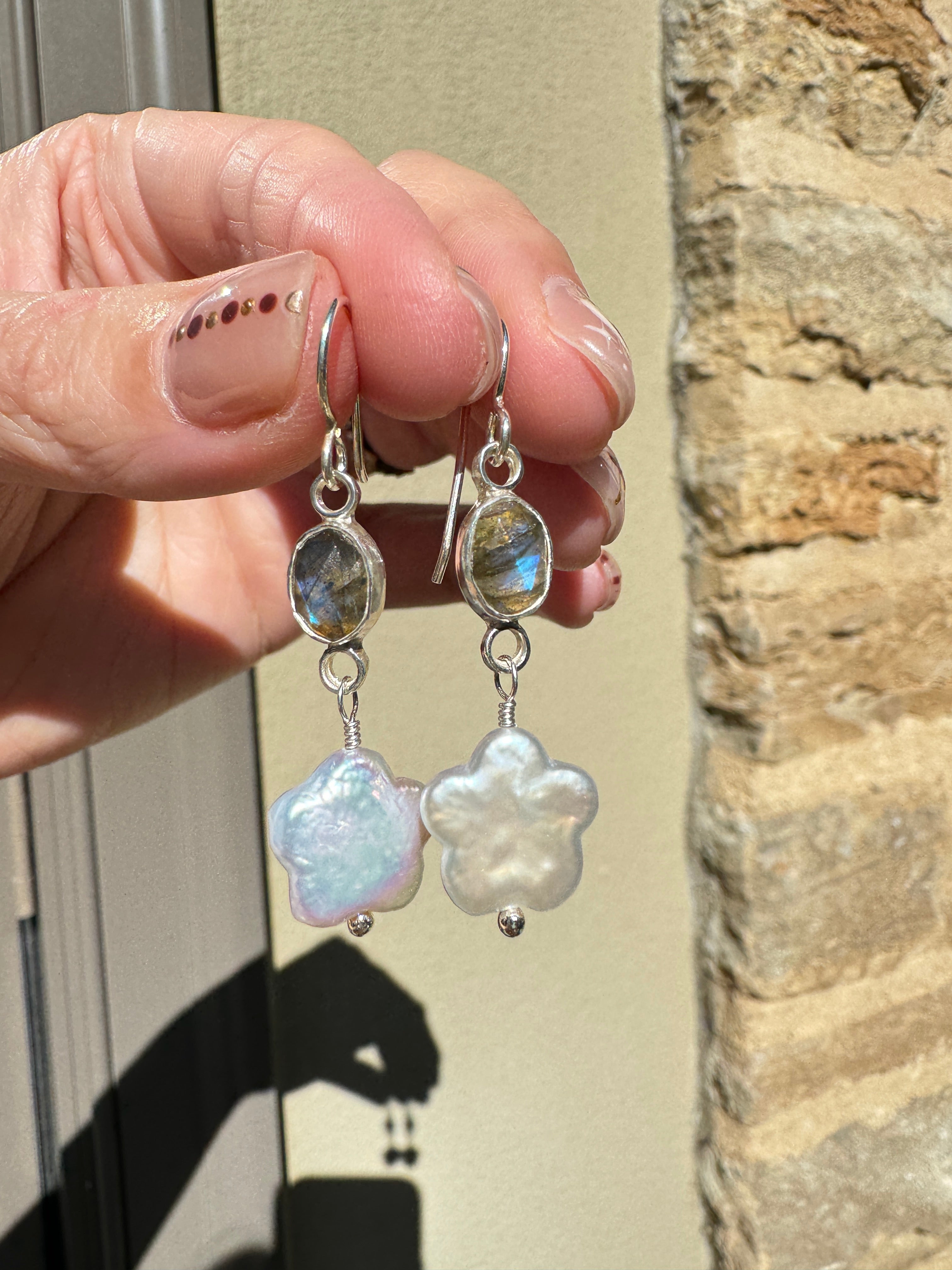 Icy blue labradorite set in a fine silver bezel on a sterling silver back with freshwater flower-shaped pearls dangling below.