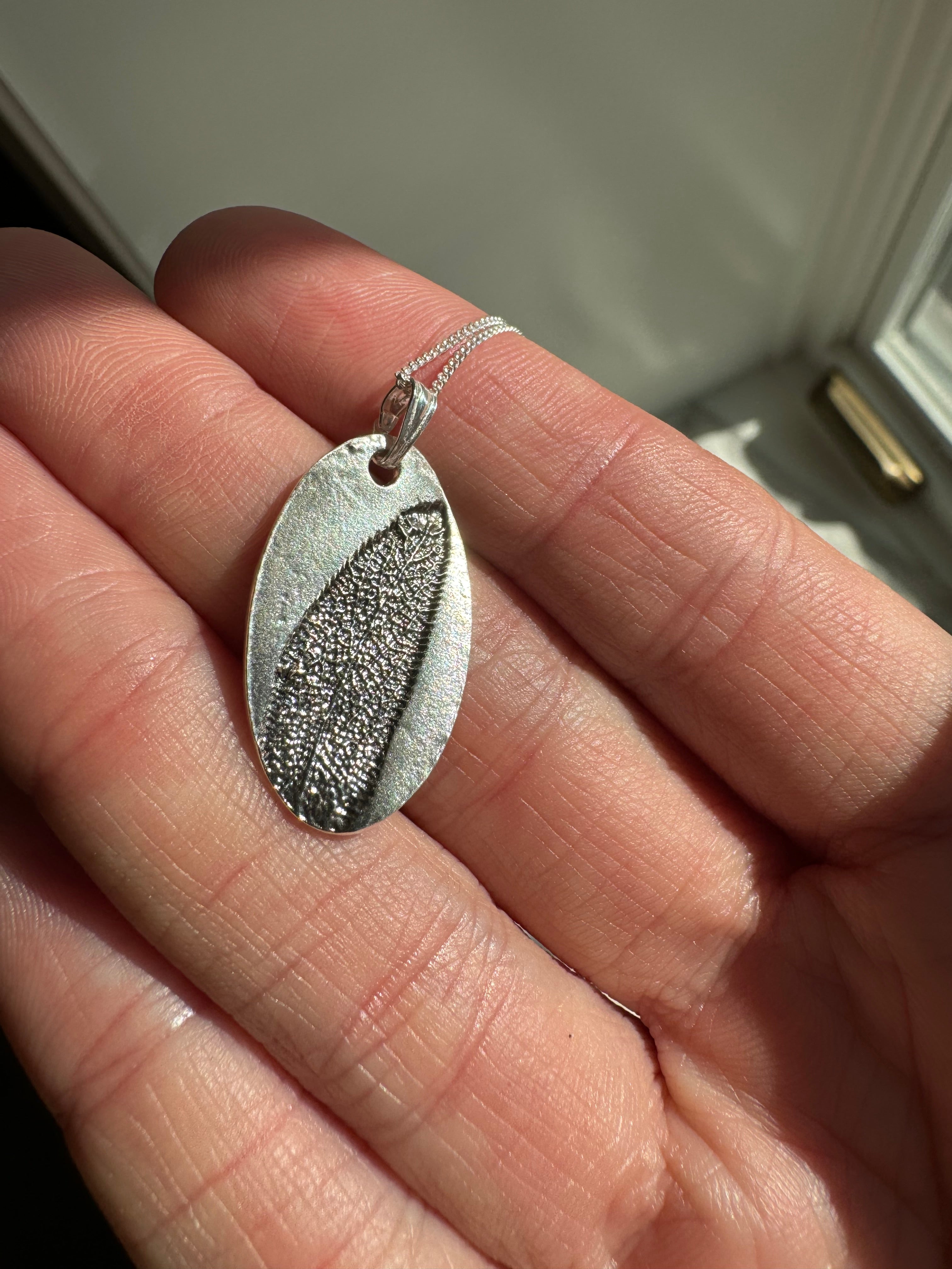 Sage imprint pendant in fine silver with a sterling silver bail. Choose between a 16" or 18" sterling silver chain. Each pendant is hand pressed and one of a kind.