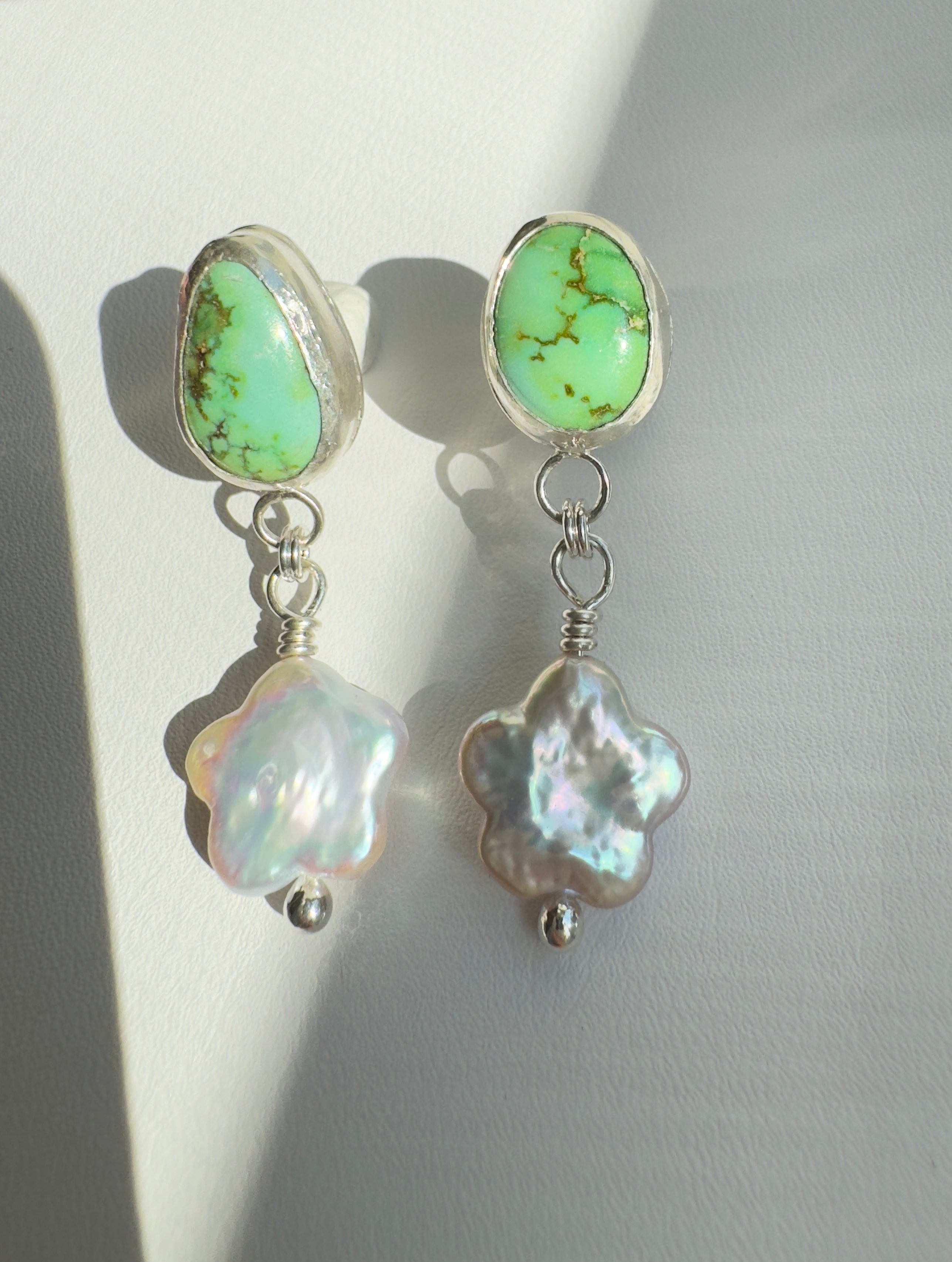 Verde Valley Turquoise set in a fine silver bezel with flower shaped pearls dangling below. The posts and ear backs are sterling silver.