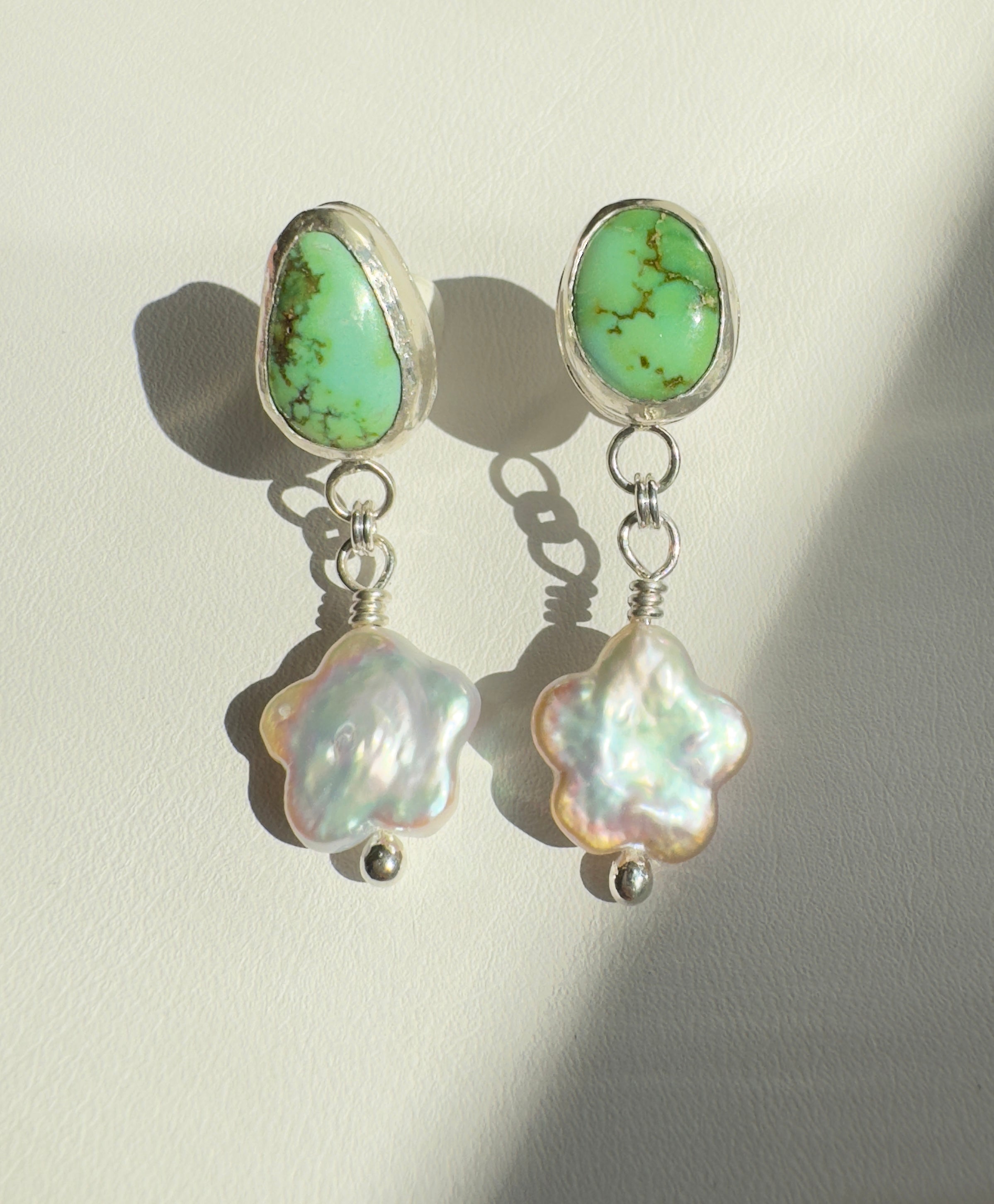 Verde Valley Turquoise set in a fine silver bezel with flower shaped pearls dangling below. The posts and ear backs are sterling silver.