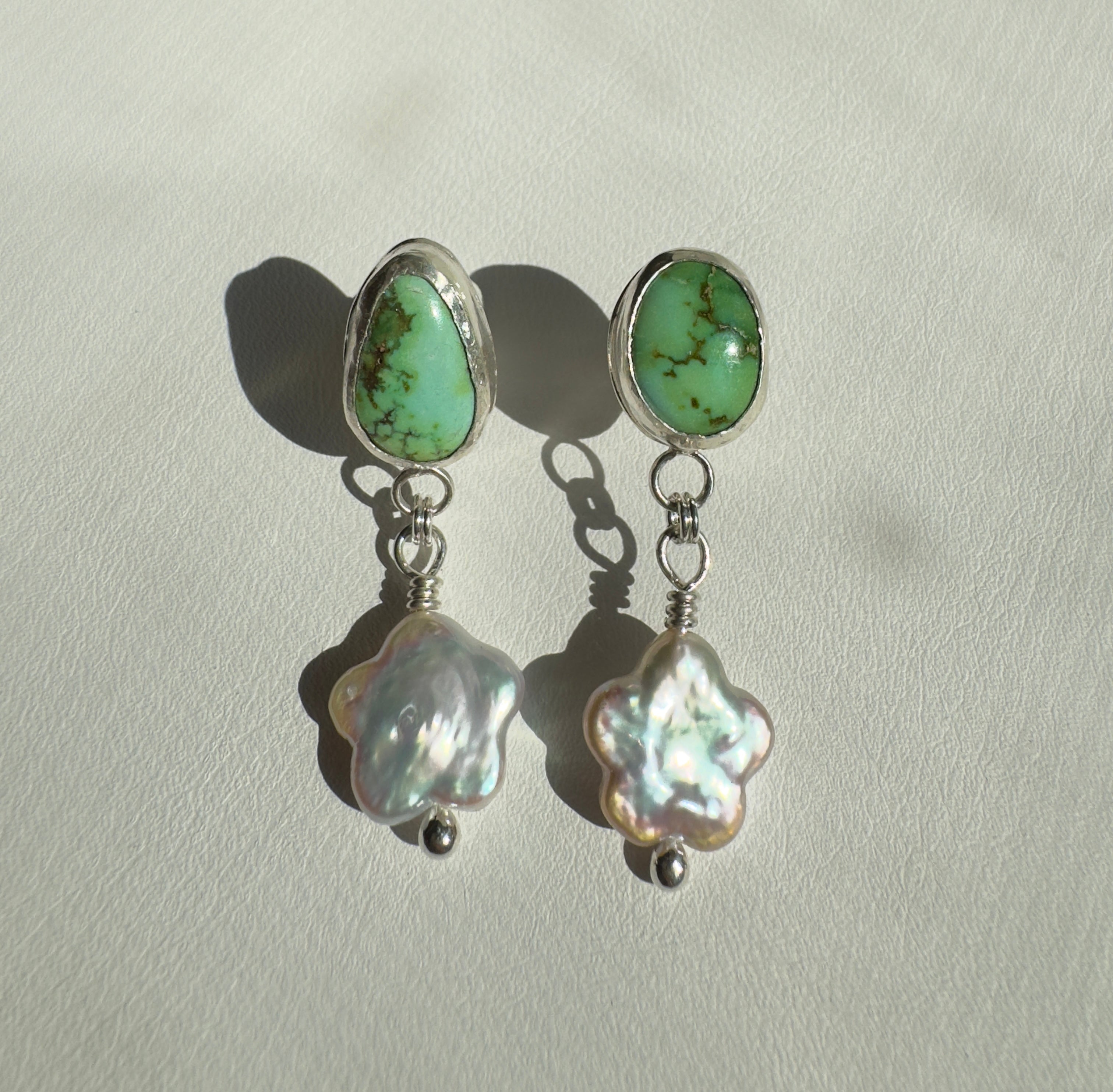 Verde Valley Turquoise set in a fine silver bezel with flower shaped pearls dangling below. The posts and ear backs are sterling silver.