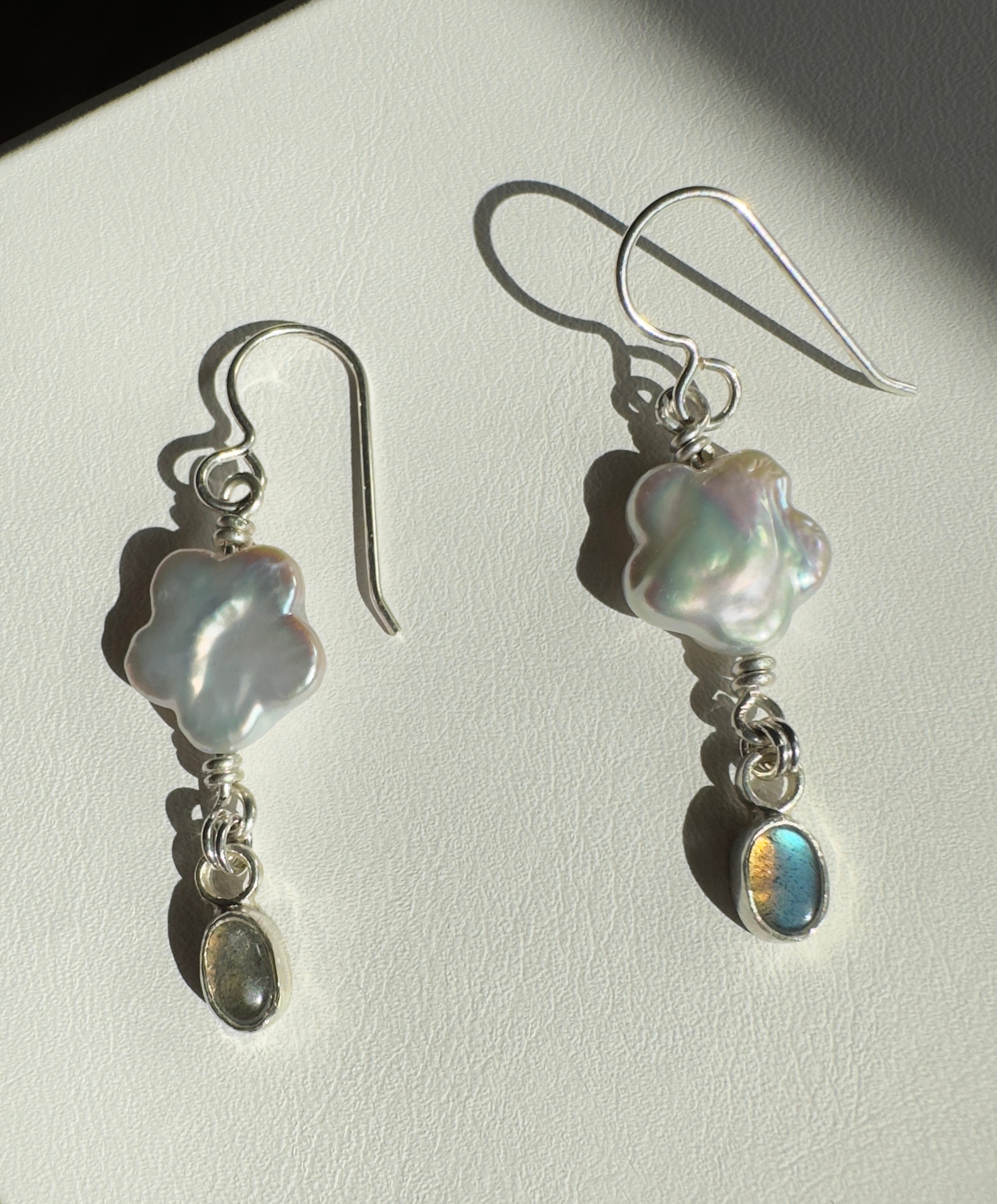 Freshwater flower shaped pearls with 4x6mm icy blue labradorite set in a fine silver bezel on a sterling silver back. 