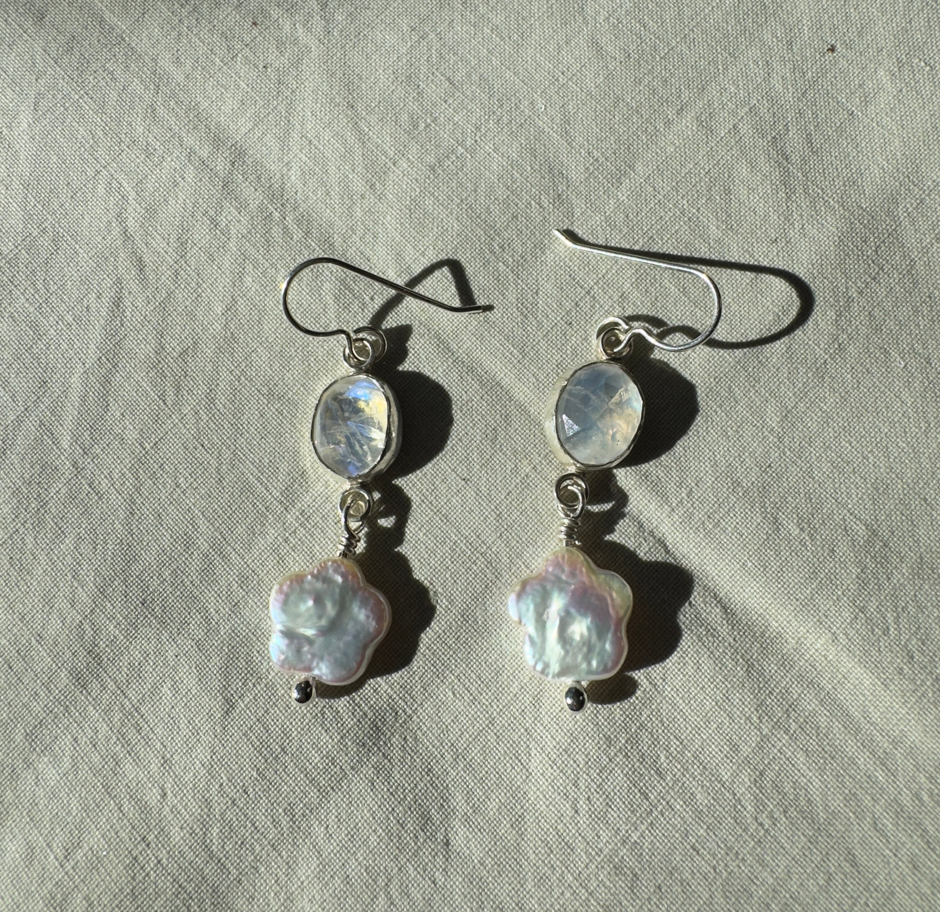 Sparkly moonstone set in a fine silver bezel on a sterling silver back with freshwater flower-shaped pearls dangling below.